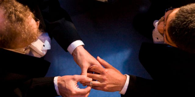 FILE - In this file photo taken June 17, 2008, John Lewis, left, puts a wedding ring on the hand of Stuart Gaffney, both of San Francisco, as they exchange marriage vows at City Hall in San Francisco. County clerk offices opened their doors June 17, 2008, to hundreds of gay and lesbian couples with appointments to secure marriage licenses and exchange vows on the first full day same-sex nuptials were legal throughout California. (AP Photo/Darryl Bush, File)