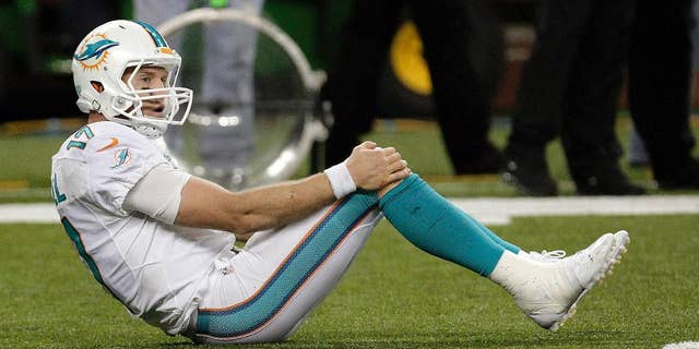 Miami Dolphins quarterback Ryan Tannehill rights himself after the final play in the fourth quarter of an NFL football game against the Detroit Lions in Detroit, Sunday, Nov. 9, 2014. Detroit won 20-16. (AP Photo/Paul Sancya)