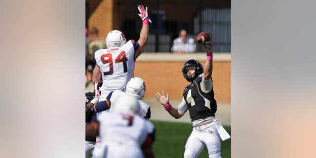 Wake Forest's Tyler Cameron (4) tries to throw a pass over Syracuse's Robert Welsh (94) during the second half of an NCAA college football game in Winston-Salem, N.C., Saturday, Oct. 18, 2014. Syracuse won 30-7. (AP Photo/Chuck Burton)