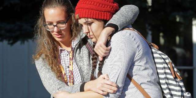Students Albany Cox, right, and Holly Hilton leave Mountain View High School where several students were stabbed Tuesday.