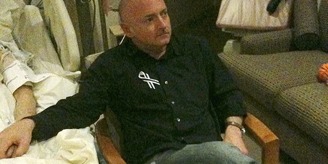 Jan. 25: A photo released by the office of U.S. Rep. Gabrielle Giffords shows Rep. Giffords husband Mark Kelly watching the State of The Union speech while holding his wife's hand in her hospital room in Houston.