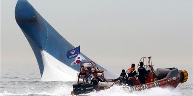 South Korean coast guard officers try to rescue passengers from a ferry sinking in the water off the southern coast near Jindo, south of Seoul, South Korea, Wednesday, April 16, 2014. The ferry carrying 459 people, mostly high school students on an overnight trip to a tourist island, sank off South Korea's southern coast on Wednesday, leaving nearly 300 people missing despite a frantic, hours-long rescue by dozens of ships and helicopters. At least four people were confirmed dead and 55 injured. (AP Photo/Yonhap) KOREA OUT