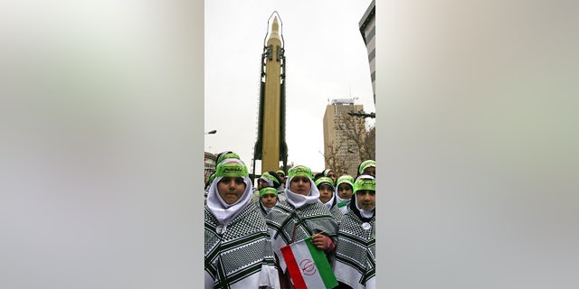 Iranian children attend an annual gathering in front of the former U.S. Embassy marking the anniversary of its 1979 takeover, while a surface-to-surface missile is displayed by the Revolutionary Guard, at rear, in Tehran, Iran, Saturday.