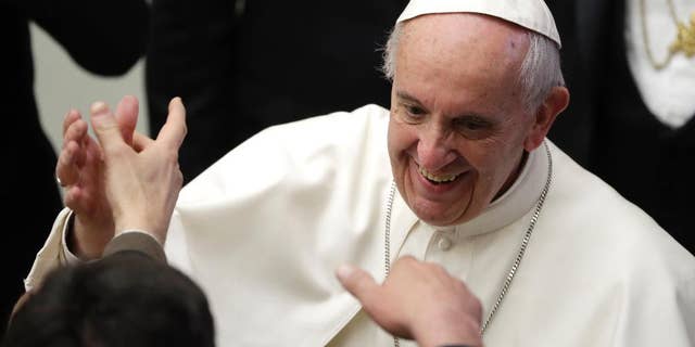 Pope Francis greets a man during an audience to exchange Christmas greetings with Vatican employees, in the Paul VI Hall, at the Vatican, Thursday, Dec. 22, 2016. (AP Photo/Gregorio Borgia)
