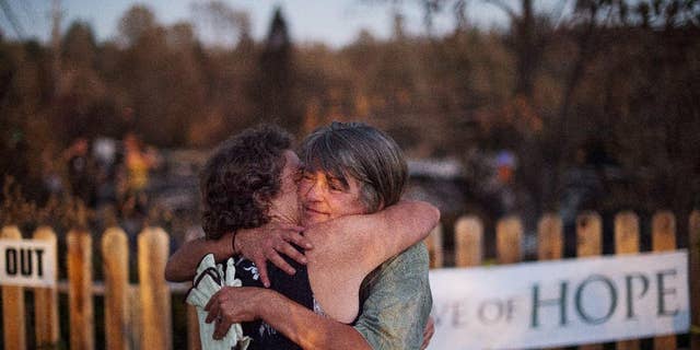 Sharon Dawson, right, who lost her home in a wildfire, embraces a friend while visiting her Middletown, Calif., property on Monday, Sept. 21, 2015. Gov. Jerry Brown requested a presidential disaster declaration on Monday, noting that more than 1,000 homes had been confirmed destroyed, with the number likely to go higher as assessment continues. (AP Photo/Noah Berger)