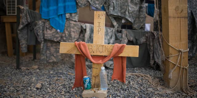 July 24: A cross sits below the guard tower where a U.S. soldier was killed while standing guard duty in Kandahar, Afghanistan.