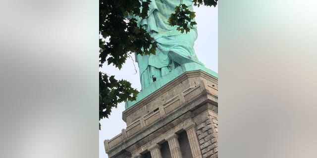 At least one person is scaling the Statue of Liberty after an "Abolish ICE" protest resulted in multiple arrests.