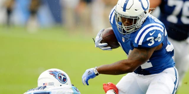 Sep 27, 2015; Nashville, TN, USA; Indianapolis Colts running back Josh Robinson (34) fights off a tackle during the second half against the Tennessee Titans at Nissan Stadium. The Colts won 35-33. Mandatory Credit: Christopher Hanewinckel-USA TODAY Sports
