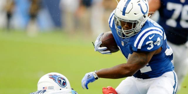 Sep 27, 2015; Nashville, TN, USA; Indianapolis Colts running back Josh Robinson (34) fights off a tackle during the second half against the Tennessee Titans at Nissan Stadium. The Colts won 35-33. Mandatory Credit: Christopher Hanewinckel-USA TODAY Sports
