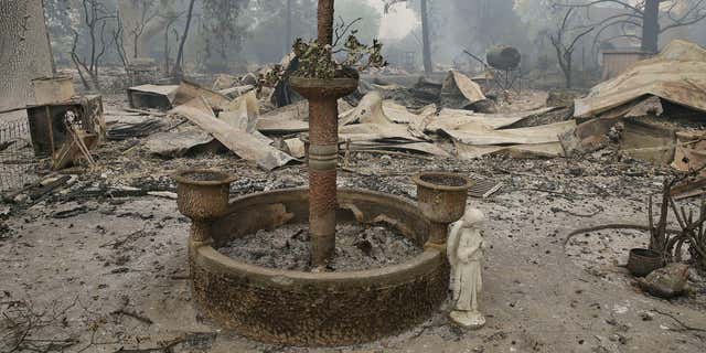 Sept. 13, 2015: A fountain and statue of an angel stand outside a home destroyed by fire in Middletown , Calif.