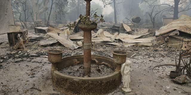 Sept. 13, 2015: A fountain and statue of an angel stand outside a home destroyed by fire in Middletown , Calif.