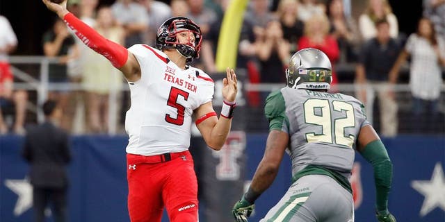 Texas Tech quarterback Patrick Mahomes (5) throws a long touchdown pass to wide receiver Zach Austin under pressure from Baylor defensive end Jamal Palmer (92) in the first half of an NCAA college football game Saturday, Oct. 3, 2015, in Arlington, Texas. (AP Photo/Tony Gutierrez)
