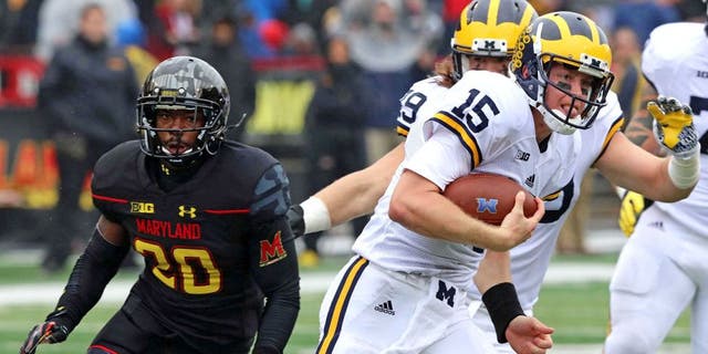 Oct 3, 2015; College Park, MD, USA; Michigan Wolverines quarterback Jake Rudock (15) runs for a gain past Maryland Terrapins defensive back Anthony Nixon (20) at Byrd Stadium. Mandatory Credit: Mitch Stringer-USA TODAY Sports