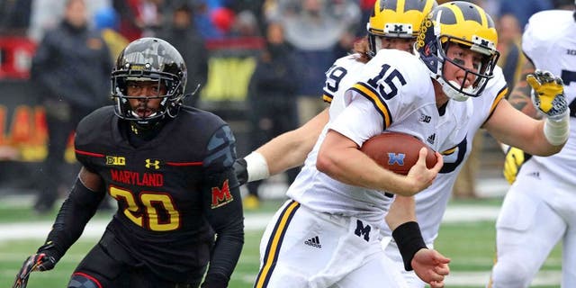 Oct 3, 2015; College Park, MD, USA; Michigan Wolverines quarterback Jake Rudock (15) runs for a gain past Maryland Terrapins defensive back Anthony Nixon (20) at Byrd Stadium. Mandatory Credit: Mitch Stringer-USA TODAY Sports