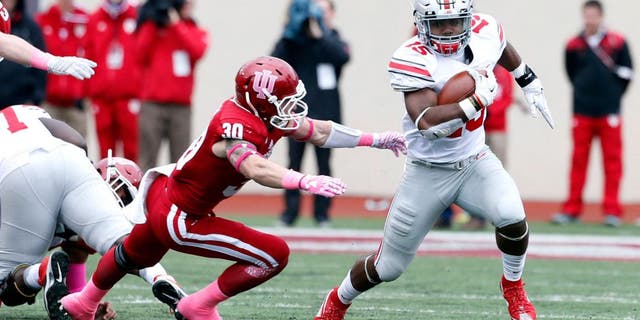 Oct 3, 2015; Bloomington, IN, USA; Ohio State Buckeyes running back Ezekiel Elliott (15) runs with the ball against Indiana Hoosiers safety Cjase Dutra (30) at Memorial Stadium. Mandatory Credit: Brian Spurlock-USA TODAY Sports