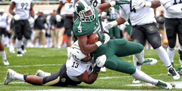 Oct 3, 2015; East Lansing, MI, USA; Michigan State Spartans running back LJ Scott (3) scores a touchdown against Purdue Boilermakers defensive end Gelen Robinson (13) during the 1st quarter of a game at Spartan Stadium. Mandatory Credit: Mike Carter-USA TODAY Sports
