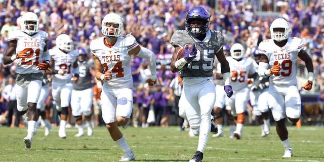 FORT WORTH, TX - OCTOBER 03: KaVontae Turpin #25 of the TCU Horned Frogs carries the ball for a touchdown against Duke Thomas #21 of the Texas Longhorns, Dylan Haines #14 of the Texas Longhorns, Peter Jinkens #19 of the Texas Longhorns in the second quarter at Amon G. Carter Stadium on October 3, 2015 in Fort Worth, Texas. (Photo by Tom Pennington/Getty Images)