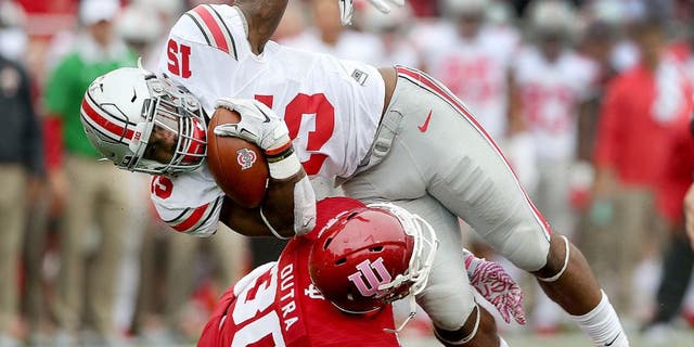 Oct 3, 2015; Bloomington, IN, USA; Ohio State Buckeyes running back Ezekiel Elliott (15) is stopped by Indiana Hoosiers defensive back Chase Dutra (30) in the first half of their game at Memorial Stadium. Mandatory Credit: Matt Kryger-USA TODAY Sports
