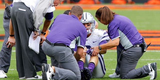 Oct 3, 2015; Stillwater, OK, USA; Kansas State Wildcats quarterback Joe Hubener (8) is looked at by trainers after getting injured in a play against the Oklahoma State Cowboys during the first quarter at Boone Pickens Stadium. Mandatory Credit: Alonzo Adams-USA TODAY Sports