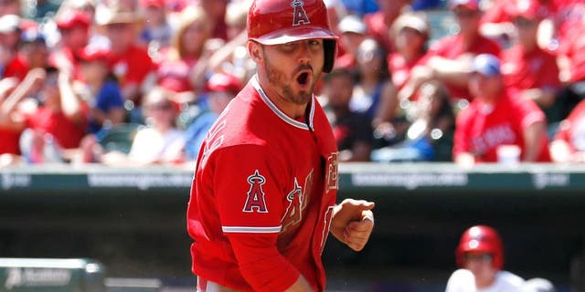 Oct 3, 2015; Arlington, TX, USA; Los Angeles Angels second baseman Johnny Giavotella (12) reacts after scoring on a wild pitch thrown by Texas Rangers starting pitcher Chi Chi Gonzalez (not shown) during the fifth inning of a baseball game at Globe Life Park in Arlington. Mandatory Credit: Jim Cowsert-USA TODAY Sports