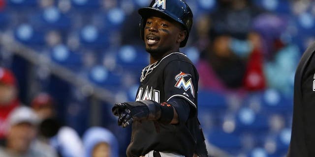 Miami Marlins Dee Gordon scores after stealing third base and advancing on a throwing error by Philadelphia Phillies catcher Carlos Ruiz, not in picture, during the sixth inning of the first game of a baseball doubleheader, Saturday, Oct. 3, 2015, in Philadelphia. (AP Photo/Rich Schultz)