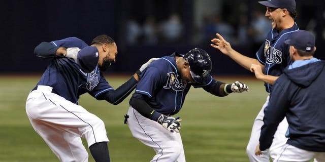 Tampa Bay Rays' Joey Butler, left, and Brad Boxberger, second from right, celebrate with Tim Beckham, center, after Beckham's two-run walk-off single to beat the Toronto Blue Jays 4-3 during the ninth inning of a baseball game Saturday, Oct. 3, 2015, in St. Petersburg, Fla. (AP Photo/Steve Nesius)