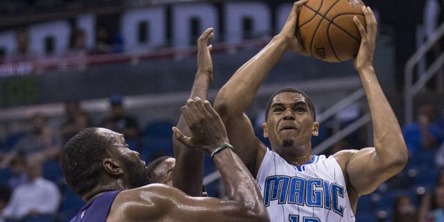 Orlando Magic forward Tobias Harris (12) shoots the ball and scores over Charlotte Hornets forward Sam Thompson (12) center and Charlotte Hornets center Al Jefferson (25) right, during the first half of an NBA basketball game in Orlando, Fla., Saturday, Oct. 3, 2015. (AP Photo/Willie J. Allen Jr.)