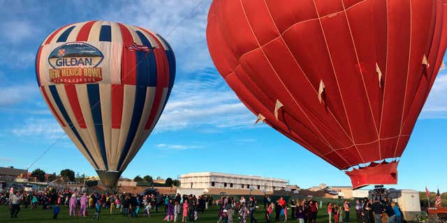 Two hot air balloons inflate at Vista Grande Elementary School in Rio Rancho, N.M. on Friday, Sept. 30, 2016, as part of the Albuquerque Aloft program that lifts balloons on school grounds as part of the 45th Albuquerque International Balloon Fiesta.