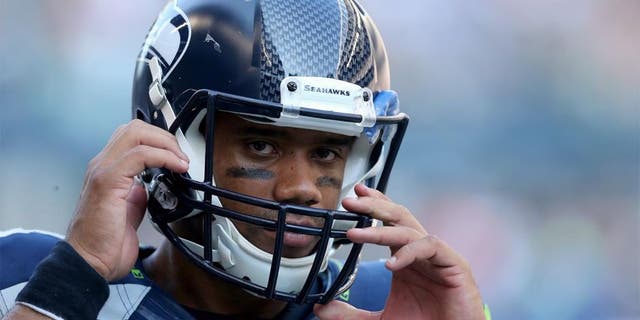 SEATTLE, WA - SEPTEMBER 21: Quarterback Russell Wilson #3 of the Seattle Seahawks adjusts his helmet against the Denver Broncos at CenturyLink Field on September 21, 2014 in Seattle, Washington. (Photo by Jeff Gross/Getty Images) *** Local Caption *** Russell Wilson