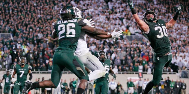 Sep 12, 2015; East Lansing, MI, USA; Michigan State Spartans linebacker Riley Bullough (30) and safety Rj Williamson (26) defend Oregon Ducks wide receiver Byron Marshall (9) during the fourth quarter at Spartan Stadium. Spartans beat the Ducks 31-28. Mandatory Credit: Raj Mehta-USA TODAY Sports