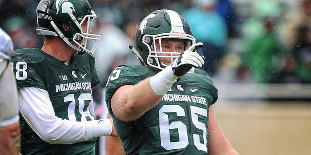 Oct 3, 2015; East Lansing, MI, USA; Michigan State Spartans offensive lineman Brian Allen (65) points out coverage before the snap of the ball during the 2nd half of a game at Spartan Stadium. MSU won 24-21. Mandatory Credit: Mike Carter-USA TODAY Sports