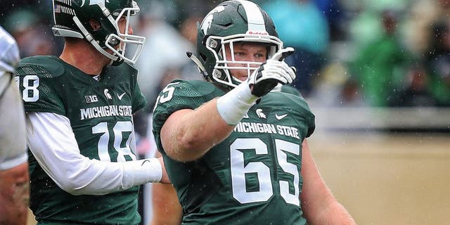 Oct 3, 2015; East Lansing, MI, USA; Michigan State Spartans offensive lineman Brian Allen (65) points out coverage before the snap of the ball during the 2nd half of a game at Spartan Stadium. MSU won 24-21. Mandatory Credit: Mike Carter-USA TODAY Sports
