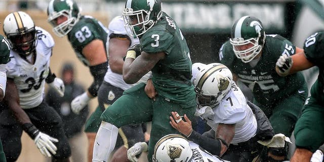 Oct 3, 2015; East Lansing, MI, USA; Michigan State Spartans running back LJ Scott (3) is tackled by Purdue Boilermakers linebacker Andy James Garcia (42) and Purdue Boilermakers safety Robert Gregory (7) during the 2nd half of a game at Spartan Stadium. MSU won 24-21. Mandatory Credit: Mike Carter-USA TODAY Sports