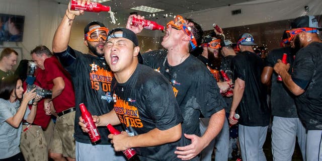 PHOENIX, AZ - OCTOBER 4: Hank Conger #16 of the Houston Astros celebrates with his team after clinching an American League wild card spot after a MLB game against the Arizona Diamondbacks on October 4, 2015 at Chase Field in Phoenix, Arizona. (Photo by Darin Wallentine/Getty Images)