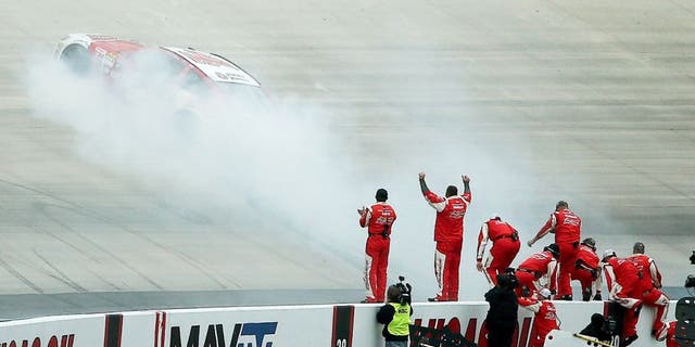 DOVER, DE - OCTOBER 04: Kevin Harvick, driver of the #4 Budweiser/Jimmy John's Chevrolet, celebrates with a burnout in front of his crew after winning the NASCAR Sprint Cup Series AAA 400 at Dover International Speedway on October 4, 2015 in Dover, Delaware. (Photo by Patrick Smith/Getty Images)