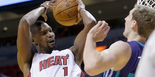 Miami Heat forward Chris Bosh (1) is fouled by Charlotte Hornets forward Cody Zeller (40) as Bosh goes to the basket in the first half of an NBA preseason basketball game, Sunday, Oct. 4, 2015, in Miami. (AP Photo/Alan Diaz)