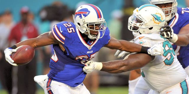 Sep 27, 2015; Miami Gardens, FL, USA; Buffalo Bills running back LeSean McCoy (25) is tackled by Miami Dolphins defensive tackle Earl Mitchell (90) during the first half at Sun Life Stadium. Mandatory Credit: Steve Mitchell-USA TODAY Sports
