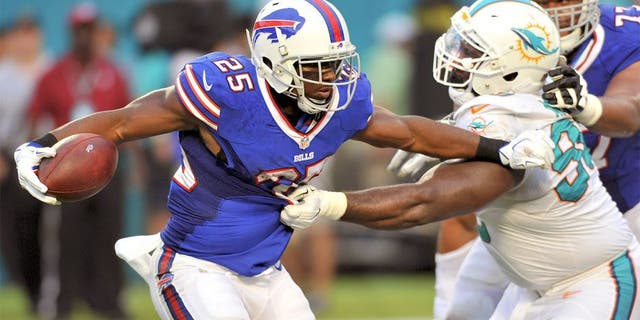 Sep 27, 2015; Miami Gardens, FL, USA; Buffalo Bills running back LeSean McCoy (25) is tackled by Miami Dolphins defensive tackle Earl Mitchell (90) during the first half at Sun Life Stadium. Mandatory Credit: Steve Mitchell-USA TODAY Sports
