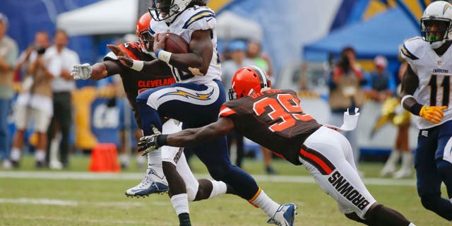 San Diego Chargers running back Melvin Gordon moves past Cleveland Browns free safety Tashaun Gipson (39) and cornerback Justin Gilbert, left, during the first half in an NFL football game Sunday, Oct. 4, 2015, in San Diego. (AP Photo/Lenny Ignelzi)
