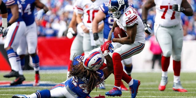 Oct 4, 2015; Orchard Park, NY, USA; New York Giants wide receiver Odell Beckham (13) runs after a catch and is tackled by Buffalo Bills cornerback Stephon Gilmore (24) during the first quarter at Ralph Wilson Stadium. Mandatory Credit: Kevin Hoffman-USA TODAY Sports
