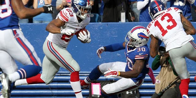 Oct 4, 2015; Orchard Park, NY, USA; New York Giants wide receiver Odell Beckham (13) blocks Buffalo Bills strong safety Bacarri Rambo (30) as New York Giants running back Rashad Jennings (23) runs the ball in the endzone for a second half touchdown at Ralph Wilson Stadium. Giants beat the Bills 24 to 10. Mandatory Credit: Timothy T. Ludwig-USA TODAY Sports