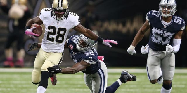 Oct 4, 2015; New Orleans, LA, USA; New Orleans Saints running back C.J. Spiller (28) breaks the tackle of Dallas Cowboys strong safety Barry Church (42) to score the game-winning 80-yard touchdown in overtime at Mercedes-Benz Superdome. The Saints won 26-20. Mandatory Credit: Chuck Cook-USA TODAY Sports