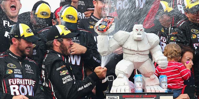 DOVER, DE - OCTOBER 02: Martin Truex Jr., driver of the #78 Furniture Row/Denver Mattress Toyota, celebrates with the trophy in Victory Lane after winning the NASCAR Sprint Cup Series Citizen Solider 400 at Dover International Speedway on October 2, 2016 in Dover, Delaware. (Photo by Sarah Crabill/NASCAR via Getty Images)