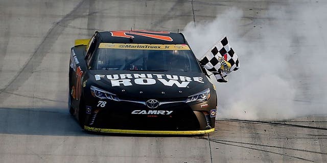 DOVER, DE - OCTOBER 02: Martin Truex Jr., driver of the #78 Furniture Row/Denver Mattress Toyota, celebrates with the checkered flag after winning the NASCAR Sprint Cup Series Citizen Solider 400 at Dover International Speedway on October 2, 2016 in Dover, Delaware. (Photo by Brian Lawdermilk/Getty Images)