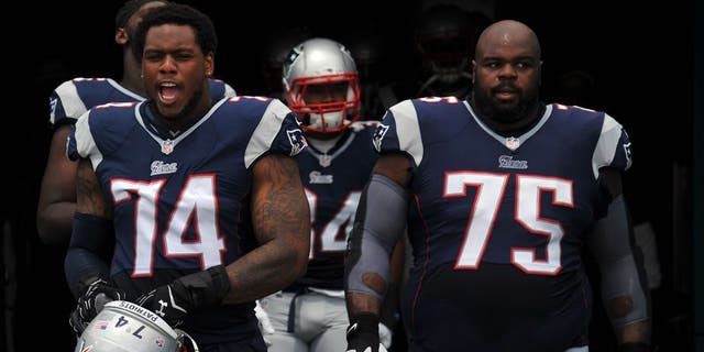 Sep 7, 2014; Miami Gardens, FL, USA; New England Patriots defensive tackle Dominique Easley (left) and defensive tackle Vince Wilfork (right) both take the field before a game against the Miami Dolphins at Sun Life Stadium. Mandatory Credit: Steve Mitchell-USA TODAY Sports