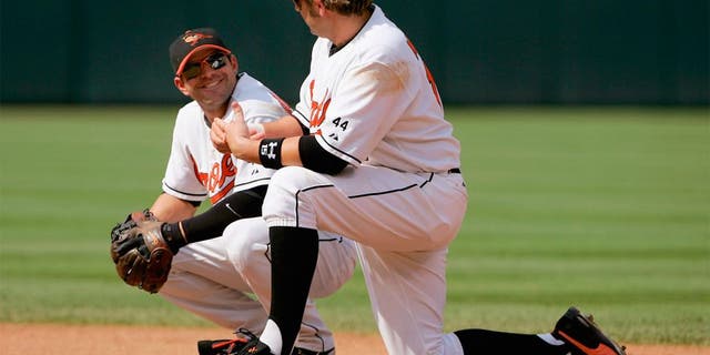 BALTIMORE - JUNE 04: First baseman Kevin Millar #15 and second baseman Brian Roberts #1 of the Baltimore Orioles chat as they await a pitching change against the New York Yankees as the Orioles defeated the Yankees 11-4 at Oriole Park at Camden Yards on June 4, 2006 in Baltimore, Maryland. (Photo by Doug Pensinger/Getty Images)