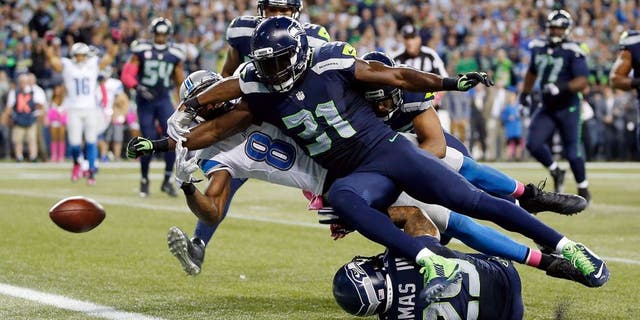 SEATTLE, WA - OCTOBER 05: Kam Chancellor #31 of the Seattle Seahawks forces Calvin Johnson #81 of the Detroit Lions to fumble the ball near the goal line during the fourth quarter of their game at CenturyLink Field on October 5, 2015 in Seattle, Washington. (Photo by Otto Greule Jr/Getty Images)