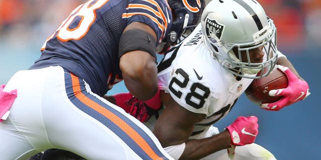 Oct 4, 2015; Chicago, IL, USA; Oakland Raiders running back Latavius Murray (28) is tackled by Chicago Bears free safety Adrian Amos (38) and linebacker Lamarr Houston (99) during the second quarter at Soldier Field. Mandatory Credit: Jerry Lai-USA TODAY Sports