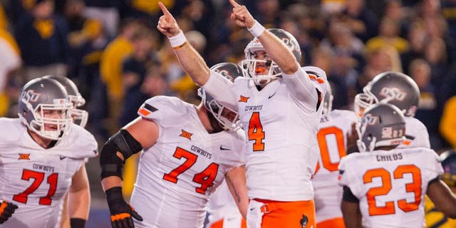 Oct 10, 2015; Morgantown, WV, USA; Oklahoma State Cowboys quarterback J.W Walsh celebrates after a touchdown during the third quarter against the West Virginia Mountaineers at Milan Puskar Stadium. Mandatory Credit: Ben Queen-USA TODAY Sports