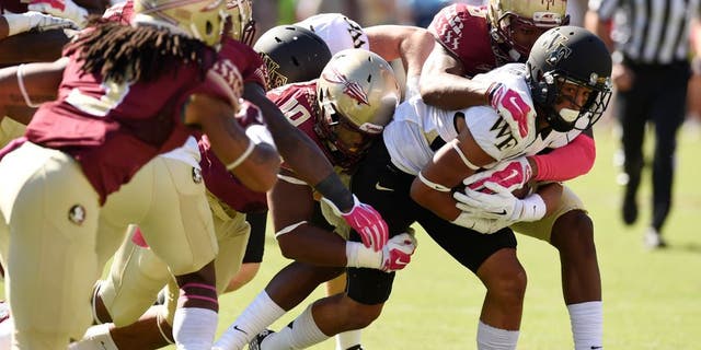 Oct 4, 2014; Tallahassee, FL, USA; Wake Forest Demon Deacons wide receiver Jared Crump (88) gets wrapped up by Florida State Seminoles linebacker E.J. Levenberry (10) and defensive back Jalen Ramsey (8) during the first quarter at Doak Campbell Stadium. Mandatory Credit: John David Mercer-USA TODAY Sports